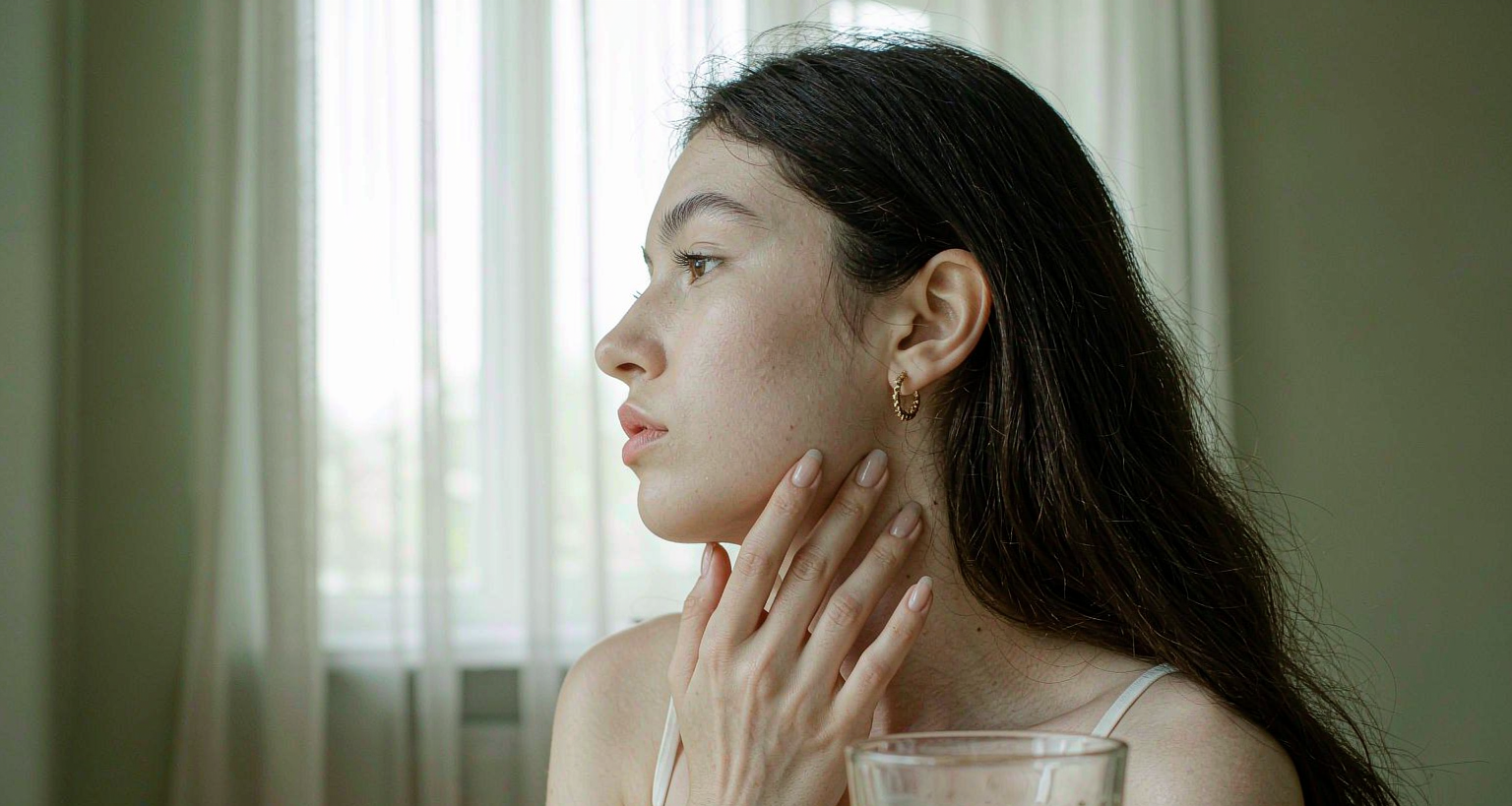 Calm woman with clear skin and a glass of fermented drink